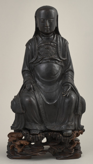 Rzeźba chińska przedstawiająca siedzącą boginię. Rzeźba ustawiona na postumencie w kształcie krzesła.Przód