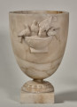 Waza alabastrowa. Czara zdobiona jest półplastycznym motywem dekoracyjnym przedstawiającym cztery gołębie stojące na brzegu misy, z których jeden pije z niej wodę.