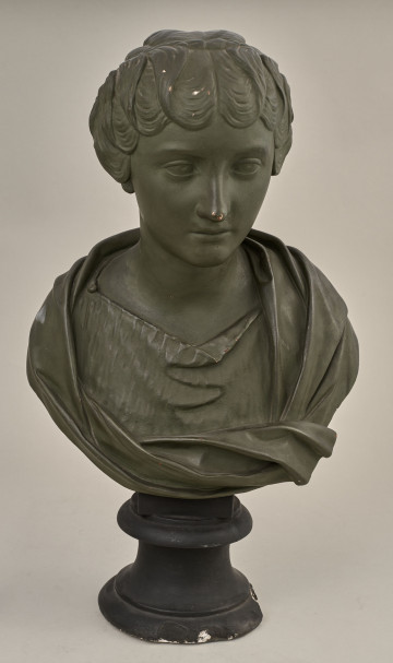 Faustyna Młodsza. Popiersie gipsowe patynowane jest na ciemnozielono. Przedstawia ono młodą kobietę, z głową zwróconą lekko w lewo, o regularnych rysach twarzy.