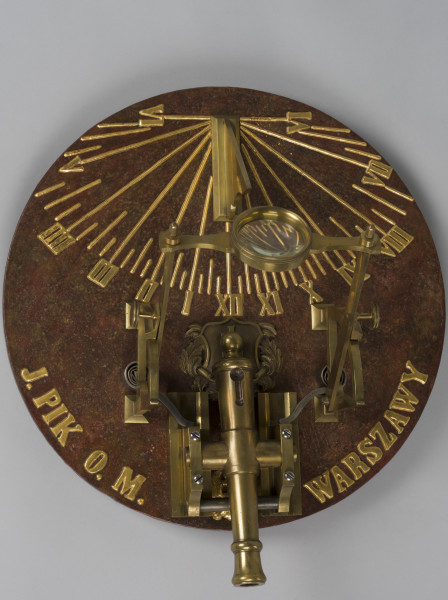 zbliżenie na płytę podstawy zegara z malowaną imitacją powierzchni marmurowej oraz wypukłe, malowane na złoto oznakowania godzin cyframi rzymskimi
