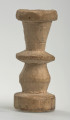 Ujęcie z boku [4]. Ze względu na swój okrągły kształt kolejne ujęcia z boku nie różnią się między sobą znacząco. Wieża została wykonana ręcznie z jednego kawałka jasnego drewna. Na całej powierzchni widoczne są ślady rzeźbienia przy pomocy noża. Obiekt w kolorze naturalnego drewna (nie został pomalowany, ani polakierowany). Wieża składa się ze spłaszczonej podstawy w formie krążka, środkowej części w formie walca szerszego po środku, spłaszczonego cylindrycznego elementu, który zwęża się stopniowo ku górze oraz ku dołowi (przypominając dwa połączone ze sobą talerze, z których każdy skierowany jest dnem do zewnątrz) oraz zwieńczenia w kształcie kielicha, ozdobionego przy pomocy linii (żłobień).