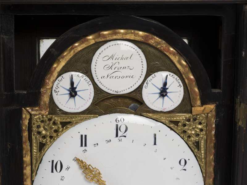 zbliżenie na tarczę zegara ze wskazaniami kalendarza, dni miesiąca, godzinami, kwadransami, minutami i sekundami, z repetierem