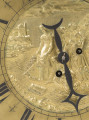 zbliżenie na dekoracyjną tarczę stanowiącą korpus zegara - ozdobiona w centrum płaskorzeźbioną, złoconą sceną biblijną przedstawiającą znalezienie przez córkę faraona małego Mojżesza w koszu płynącym po Nilu