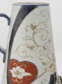zbliżenie na dekorację brzuśca - stylizowana winna latorośl i błękitne pasy ze złotą stylizowaną arabeską