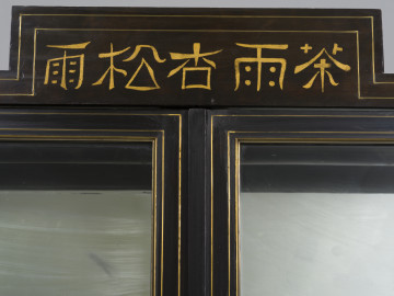 zbliżenie na zwieńczenie szafy ze znakami chińskimi