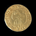 skarb monet - Ujęcie awersu jednej ze złotych monet ze skarbu. Skarb 656 szelągów krzyżackich i 2 guldenów niemieckich ukryty w kaflu piecowym pod koniec XV wieku.