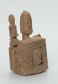 drewniane pudełko na fetysz - Ujęcie z przodu z prawej strony. Drewniane pudełko, dekorowane płaskorzeźbami, w środku którego widoczne są drzwiczki.