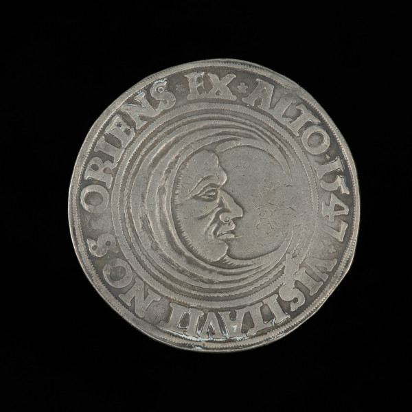talar - Ujęcie rewersu. Na rewersie monety pólksiężyc z ludzką twarzą w prawo i napis w otoku.