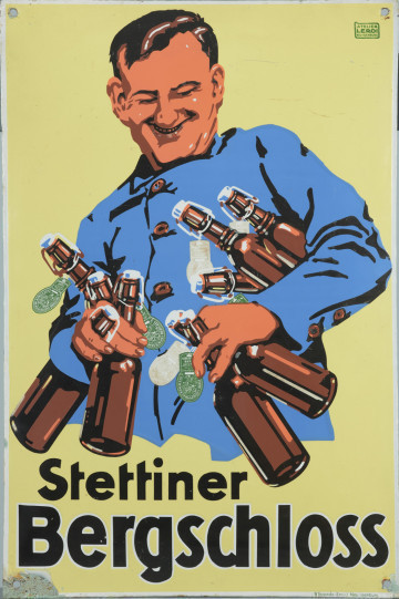 tablica reklamowa - ujęcie z przodu; Barwna emaliowana tablica reklamująca szczeciński browar Stettiner Bergschloss. Przedstawia na żółtym tle uśmiechniętego pracownika browaru w niebieskim uniformie trzymającego pod prawą ręką pięć, a w lewej trzy butelki piwa z brązowego szkła z zielonymi etykietkami browaru. Tablica otoczona jest białą ramką ograniczającą z czterema otworami w narożnikach.