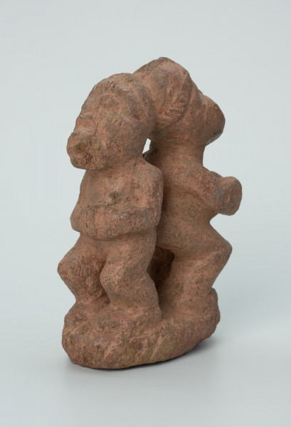 Ujęcie z przodu z lewej. Rzeźbione w brunatno-różowym kamieniu dwie połączone ze sobą postaci ludzkie w pozycji stojącej. Wyrzeźbiono je tyłem do siebie. Stykają się tyłem głowy oraz pośladkami. Widoczne rysy i mikropęknięcia.