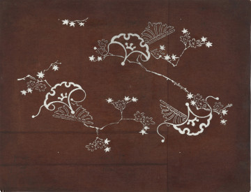 Szablon farbiarski katagami - Ujęcie z przodu. Nieduży, zabarwiony na brązowo, prostokątny szablon farbiarski typu jizomari, przedstawiający liście, kwiaty i gałązki klonu, stylizowane liście miłorzębu japońskiego oraz motywy geometryczno-roślinne.