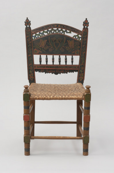 mebel - Ujęcie z przodu. Krzesło z plecionym siedziskiem, zdobione motywem florystycznym.