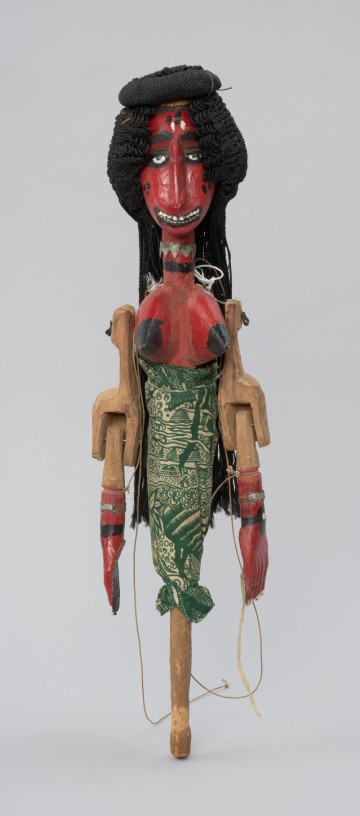 Ujęcie z przodu. Drewniana lalka teatralna, z rękoma ruchomymi w ramionach oraz w łokciach.