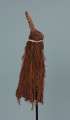 maska - Ujęcie z przodu, z prawej strony. Maska wykonana z łyka drzewa, do której przymocowany jest bawełniany sznurek.