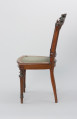 krzesło - Ujęcie z prawego boku. Tapicerowane krzesło płasko wyściełanym siedziskiem i plecionym oparciem
