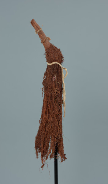 maska - Ujęcie z prawego boku. Maska wykonana z łyka drzewa, do której przymocowany jest bawełniany sznurek.