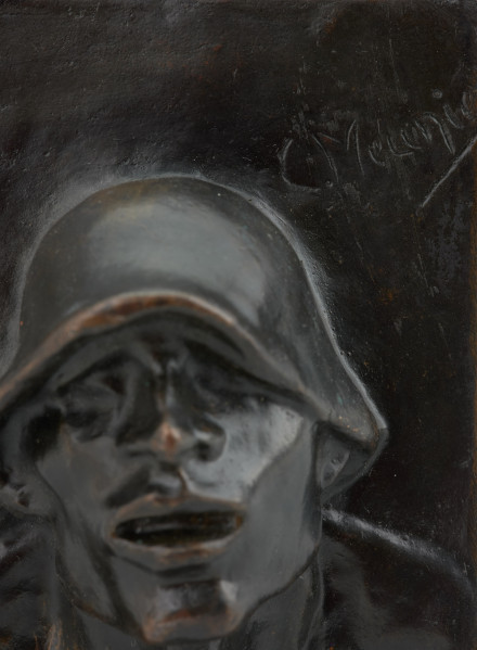 portret męski - Ujęcie detalu z podpisem autora; Płaskorzeźba przedstawiająca głowę mężczyzny. Z blachy stanowiącej tło wyłania się kwadratowa twarz z szerokim nosem i rozchylonymi ustami, szyja mocno osadzona, szeroka. Na głowie hutniczy kask. Widoczny fragment torsu.