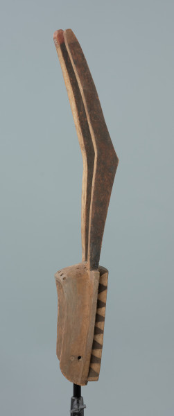 maska - Ujęcie prawego boku. Drewniana, rzeźbiona maska antylopy, z dużymi geometrycznymi otworami na oczy.