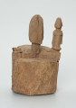 drewniane pudełko na fetysz - Ujęcie z tyłu. Drewniane pudełko, dekorowane płaskorzeźbami, w środku którego widoczne są drzwiczki.