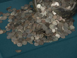 skarb monet - Ujęcie monet. Fragment glinianego naczynia z wysypującymi się z niego monetami. Skarb 2588 monet, głównie denarów pomorskich, ukryty w naczyniu glinianym po 1405-1410 roku.