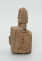 drewniane pudełko na fetysz - Ujęcie lewego boku. Drewniane pudełko, dekorowane płaskorzeźbami, w środku którego widoczne są drzwiczki.