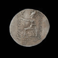 moneta; tetradrachma - Ujęcie rewersu. Moneta z wizerunkiem głowy Aleksandra Macedońskiego z rogiem Ammona na awersie i Ateną siedzącą na tronie na rewersie.