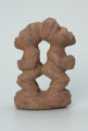 Ujęcie z  boku z lewej. Rzeźbione w brunatno-różowym kamieniu dwie połączone ze sobą postaci ludzkie w pozycji stojącej. Wyrzeźbiono je tyłem do siebie. Stykają się tyłem głowy oraz pośladkami. Widoczne rysy i mikropęknięcia.