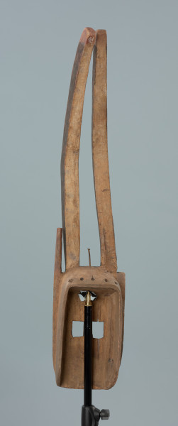 maska - Ujęcie z tyłu. Drewniana, rzeźbiona maska antylopy, z dużymi geometrycznymi otworami na oczy.