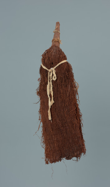 maska - Ujęcie z tyłu. Maska wykonana z łyka drzewa, do której przymocowany jest bawełniany sznurek.