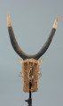 rzeźbiona maska - Ujęcie z tyłu. Drewniana, rzeźbiona maska byka, do której przymocowany jest bawełniany sznurek.