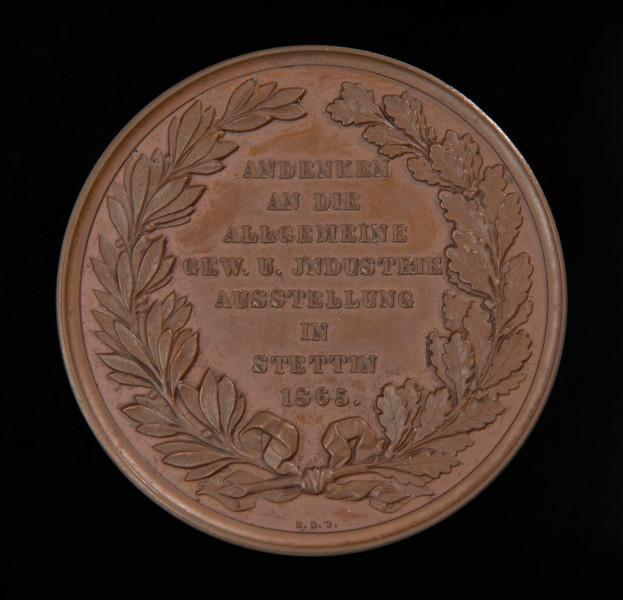 medal pamiątkowy - Ujęcie rewersu medalu. Na rewersie w wieńcu laurowo-dębowym napis. Przy rancie inicjały E.S.F.