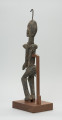 rzeźba - Ujęcie z tyłu z lewej strony. Rzeźbiona figura kobiety.