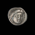moneta; didrachma - Ujęcie awersu. Moneta z wizerunkiem głowy Heliosa na awersie i kwiatem róży na rewersie.