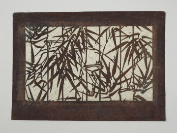 szablon farbiarski katagami; wycinanka; dekoracja - Ujęcie z przodu. Niewielki zabarwiony na brązowo prostokatny szablon farbiarski typu jishiro, przedstawiający roślinny motyw bambusa z liśćmi.