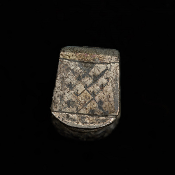 Szlufka do pendentu księcia Kazimierza VI/IX (1557-1605) - Ujęcie detalu z tyłu. Prostokątna szlufka wykonana z gładkiej, srebrnej taśmy, z ozdobnie opracowaną częścią przednią w formie tralki, pokrytą grawerowaną i niellowaną dekoracją.