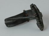 Zapinka z brązu - Ujęcie z dołu. Zapinka z brązu z tzw. „kapturkiem” pokrywającym sprężynkę oraz grzebykiem na kabłąku.