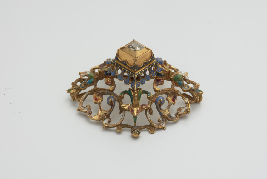 biżuteria, ozdoby - Ujęcie z boku z prawej strony. Ażurowy klejnot z kołpaka z diamentem, zdobiony barwną emalią.