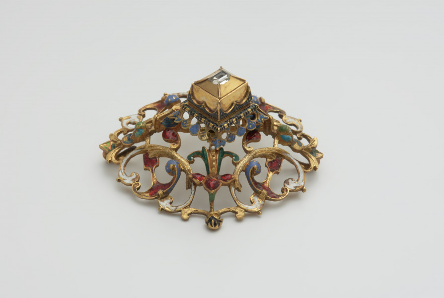 biżuteria, ozdoby - Ujęcie z boku. Ażurowy klejnot z kołpaka z diamentem, zdobiony barwną emalią.