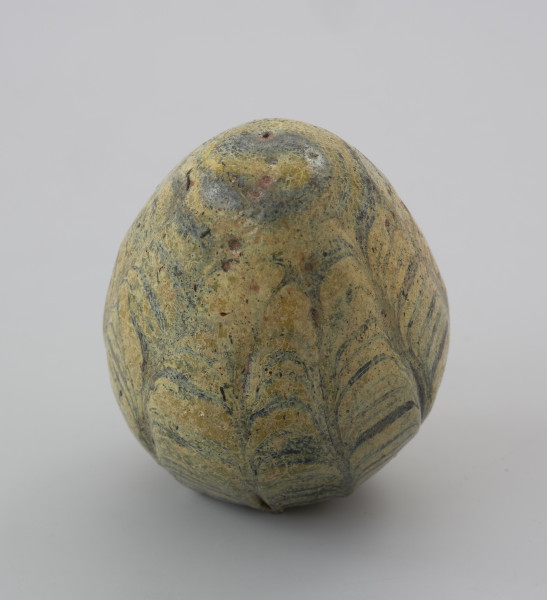 przedmiot religijny i obrzędowy - Ujęcie z góry w pionie. Gliniana grzechotka w kształcie jajka, pokryta barwnym szkliwem.