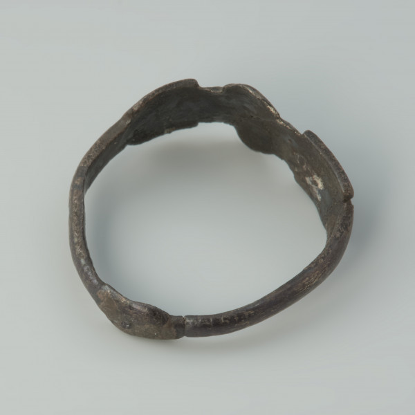 pierścionek, biżuteria - Ujęcie tyłu pierścionka skosem w prawą stronę z góry. Pierścionek srebrny z tarczką o nieregularnym kształcie.