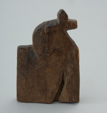 przedmiot kultowy, figurka - Ujęcie lewej strony w pionie. Figurka drewniana przedstawiająca konia z realistycznie zaznaczonym łbem i szyją.