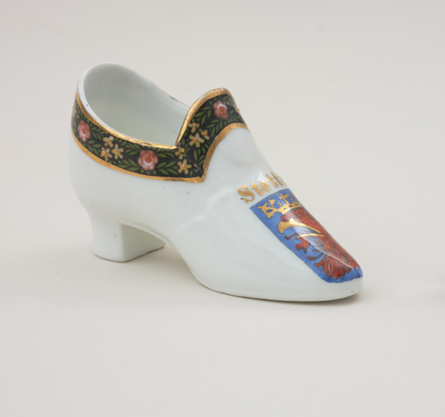 porcelanowy bucik ozdobiony malowanym szlaczkiem - Ujęcie z przodu skosem w prawą stronę. Porcelonowy bucik ozdobiony malowanym szlaczkiem.