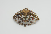 biżuteria, ozdoby - Ujęcie z boku z prawej strony. Ażurowy klejnot z kołpaka z diamentem, zdobiony barwną emalią.