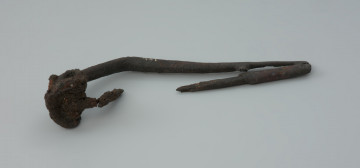 Ujęcie z przodu. Zapinka żelazna z wybrakowaną szpilą i plastycznym zdobieniem żeberkiem na zgięciu kabłąka.