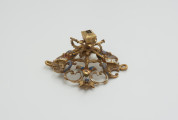 biżuteria, ozdoby - Ujęcie z boku. Ażurowy klejnot z kołpaka, perwotnie z diamentem i czterema perłami, zdobiony barwną emalią.
