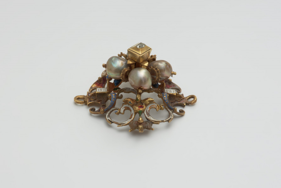 biżuteria, ozdoby - Ujęcie z boku. Ażurowy klejnot z kołpaka z diamentem i czterema perłami, zdobiony barwną emalią.