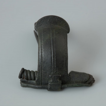 Zapinka z brązu - Ujęcie z przodu. Zapinka z brązu z tzw. „kapturkiem” pokrywającym sprężynkę oraz grzebykiem na kabłąku.