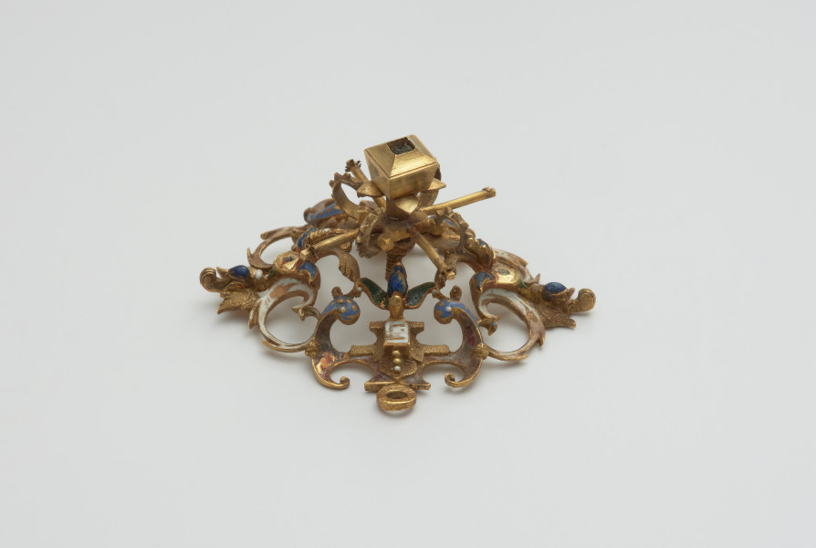 biżuteria, ozdoby - Ujęcie z boku z góry. Ażurowy klejnot z kołpaka, perwotnie z diamentem i czterema perłami, zdobiony barwną emalią.