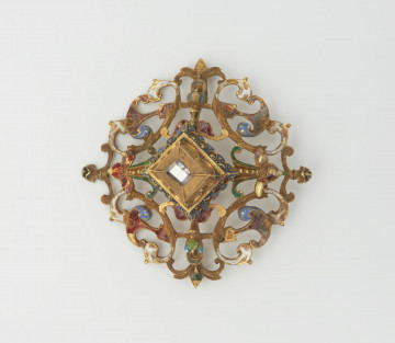 biżuteria, ozdoby - Ujęcie z przodu. Ażurowy klejnot z kołpaka z diamentem, zdobiony barwną emalią.