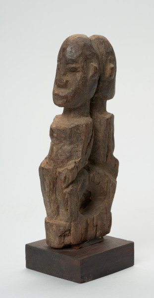 rzeźba - Ujęcie z przodu z lewej strony. Wizerunek dwóch mitycznych postaci Yebane. Stykają się od tyłu głowami, pośladkami.